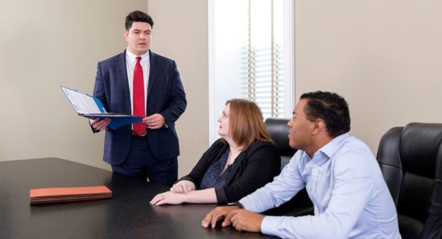 Attorney Marcus Priest speaking with clients