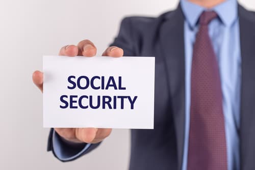 person in suit holding social security paper