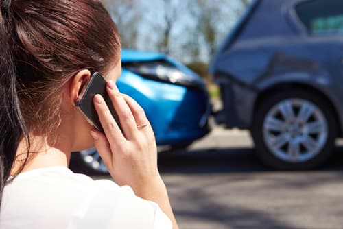 person on phone after car accident