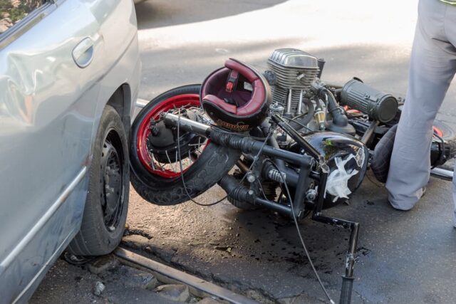 A collision between a car and a Honda motorcycle on a city street in Fort Smith.