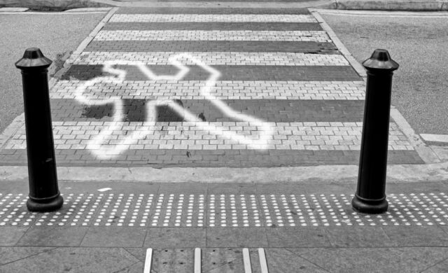 A victim chalk tracing of an accident victim on a zebra crossing junction for the concept: Dangerous crossing.