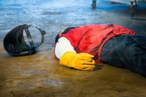 Welder fainting in factory accident, highlighting safety gear importance in construction industry.