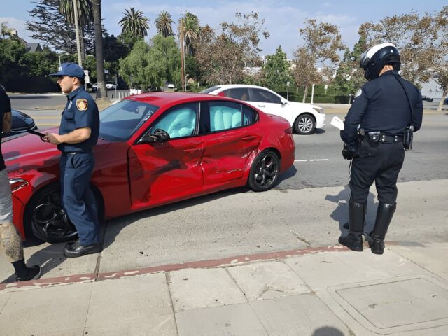 Police are investigating a traffic accident involving a red Alfa Romeo sports car